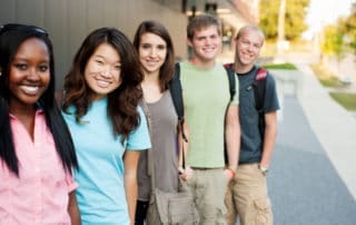 A group of teenagers posing with bright smiles.