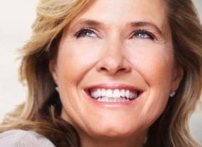 Mature lady posing with a smile, showcasing her bright white teeth at Pike District Smiles.