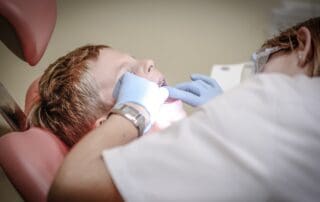 Dentist providing treatment to a child in the clinic.