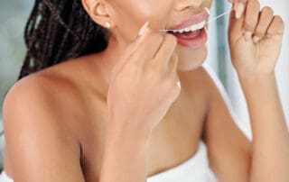 Patient flossing her teeth with dental thread.